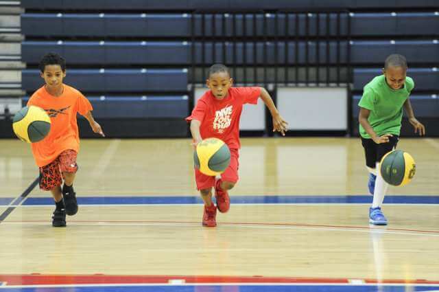 Three children playing basketball