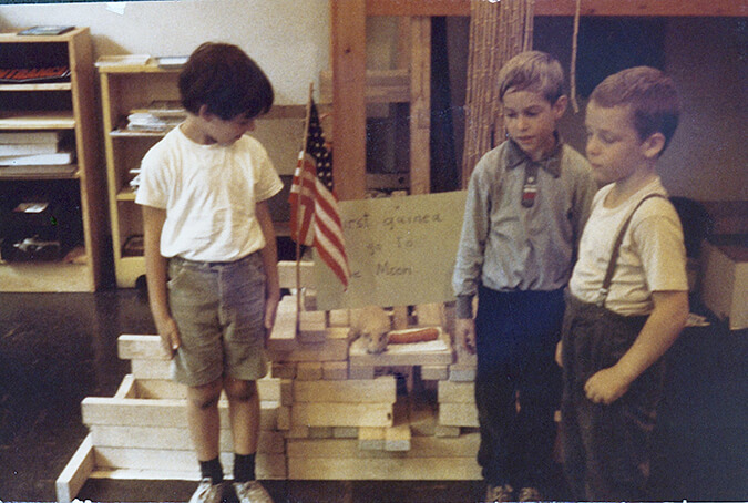 three children standing near blocks