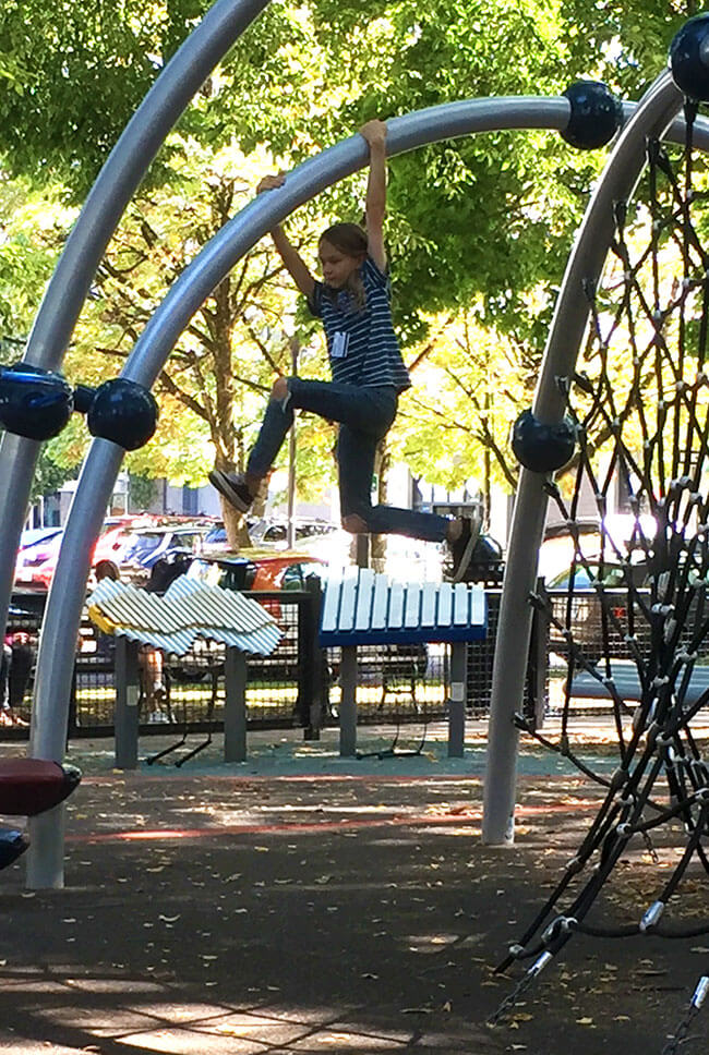 a young person climbing on a jungle gym