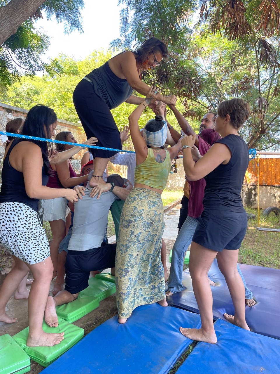 One adult standing on others shoulders being supported